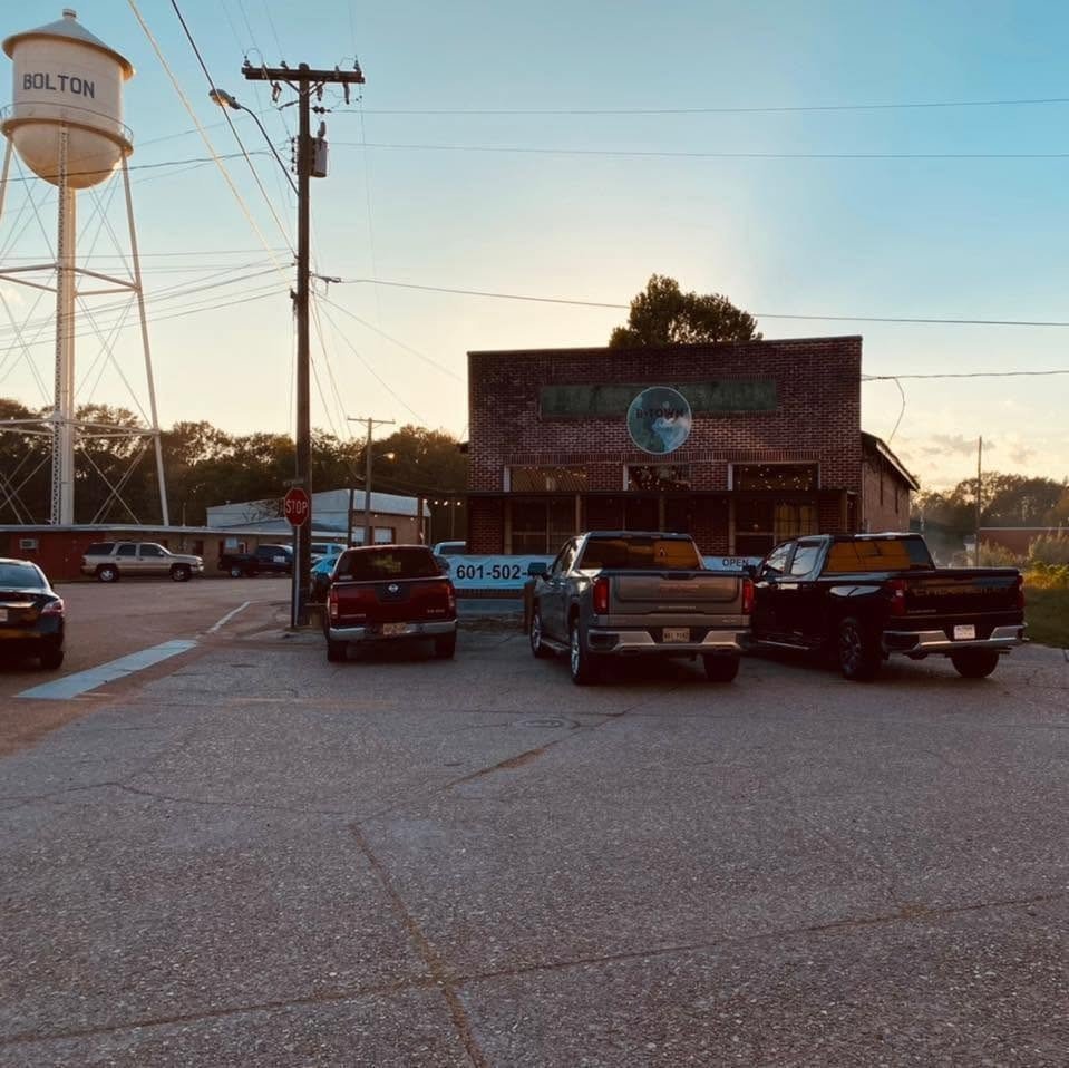 B Town Steakhouse exterior and Bolton water tower at golden hour